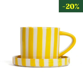 La tasse en céramique rayée avec soucoupe