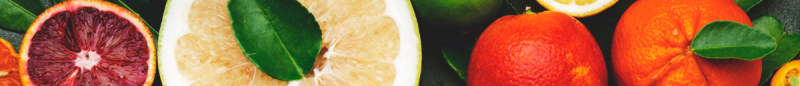 Various citric fruits in the background.