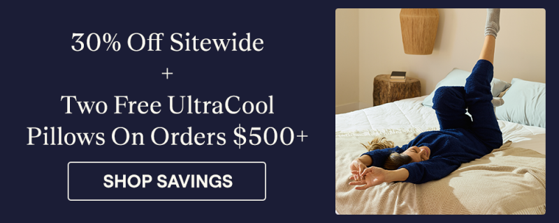 Woman laying on a bed with an Almond Woven Throw Blanket 