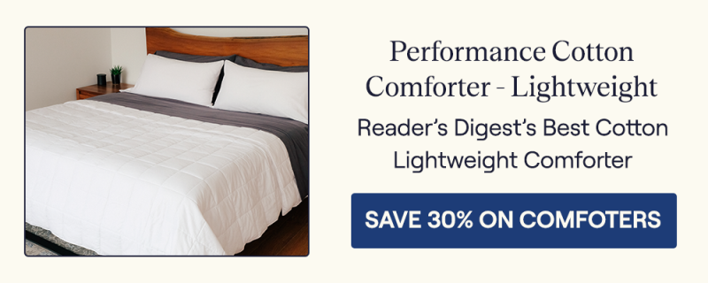 The Lightweight Performance Cotton Comforter on a bed with gray sheets