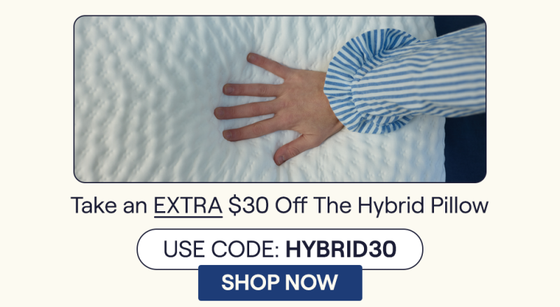 Woman's hand pressing down on the Hybrid Pillow highlighting the fluffiness of the pillow