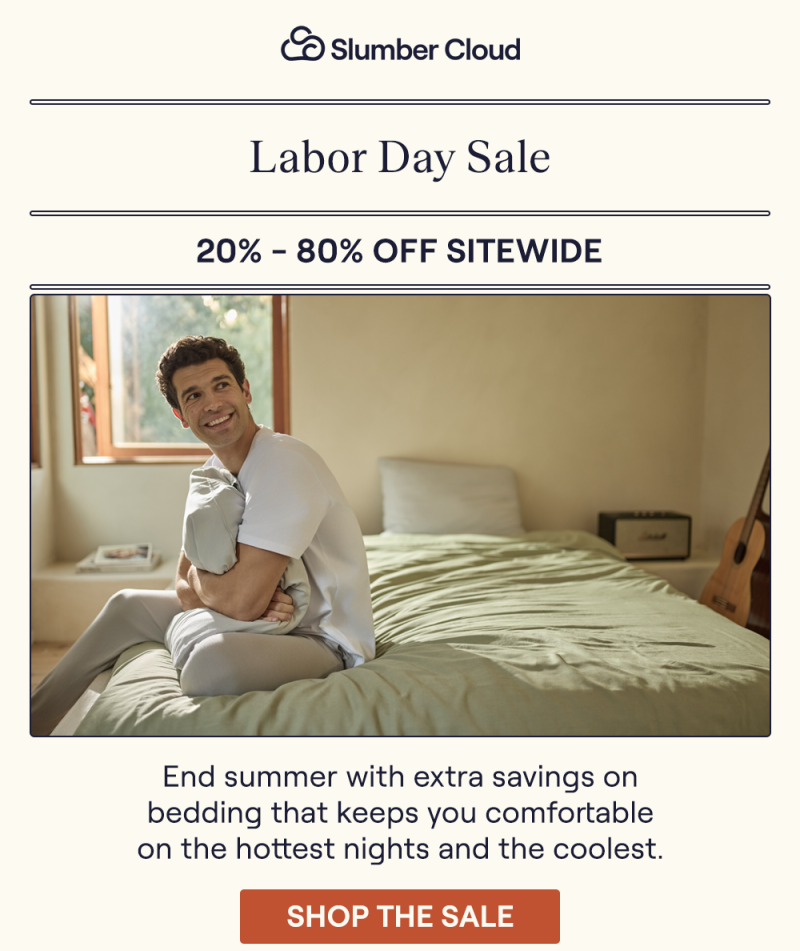 A man sitting on a bed hugging a pillow