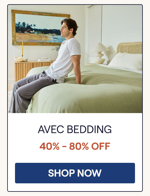 A man sitting on the edge of a bed with the Sage Align Sheet Set