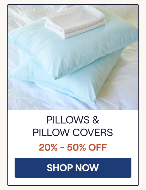 Two UltraCool Pillows stacked on a bed with a Performance Pillow Cover Set folded sitting on top