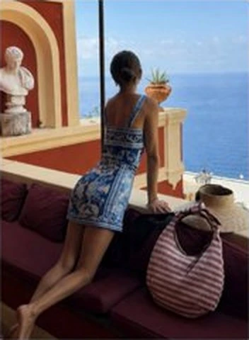 Ella overlooking the sea with The Josie Knot Bag in Tomato Stripe