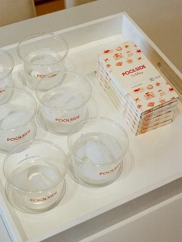 POOLSIDE cups and chocolates on a white tray
