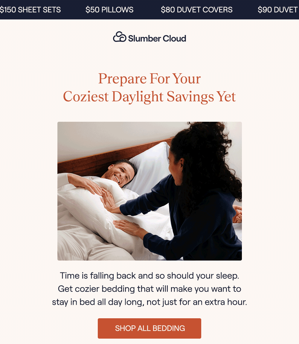 A couple sitting in bed holding a Slumber Cloud pillow